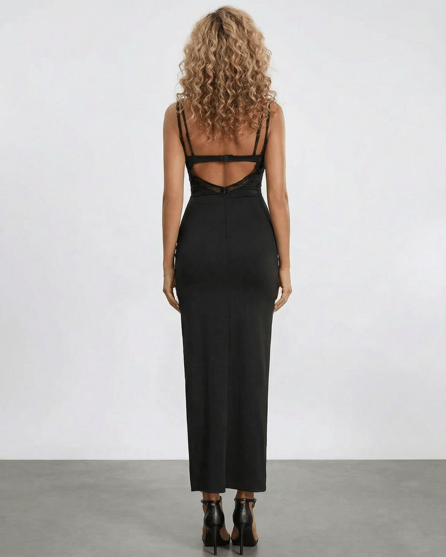 Back view of a woman wearing the Lyra Maxi Dress by Lauven, showcasing its elegant lace panel and sleek silhouette.