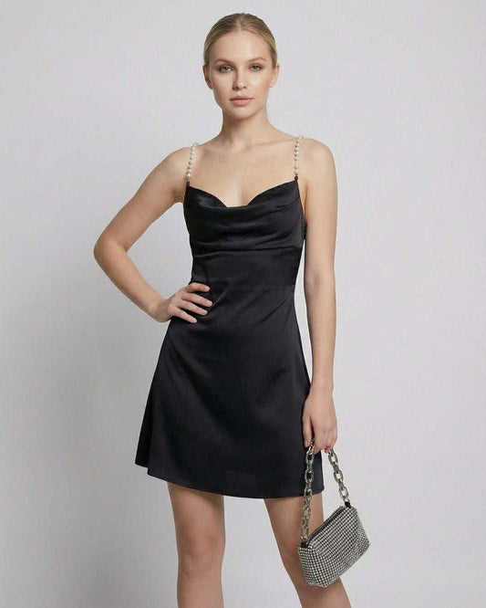 Elegant woman in Lauven Lyra Mini Dress featuring satin sheath design and pearl straps.