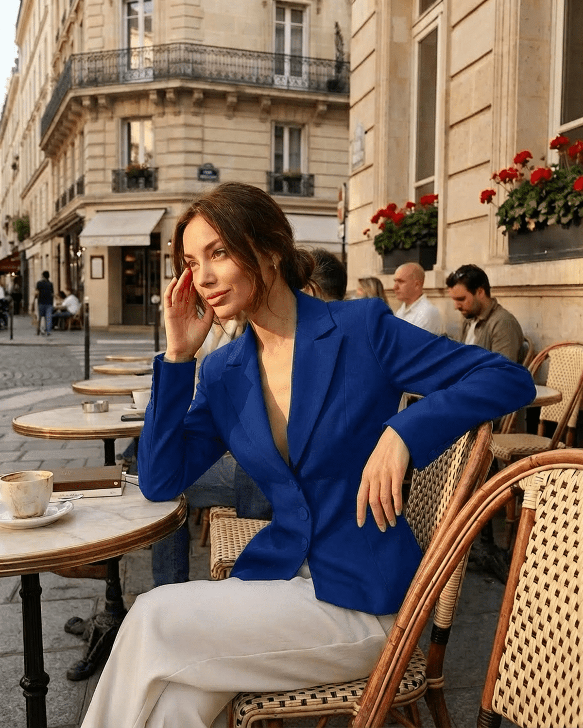 Woman in a blue Marina Blazer by Lauven enjoying coffee at a Parisian café, exuding elegance and sophistication.