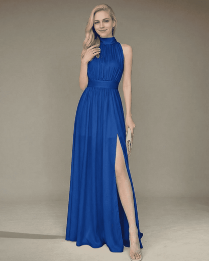 Model wearing the Lauven Marina Maxi Dress, a sleeveless turtleneck blue maxi dress with a high waist and side slit.