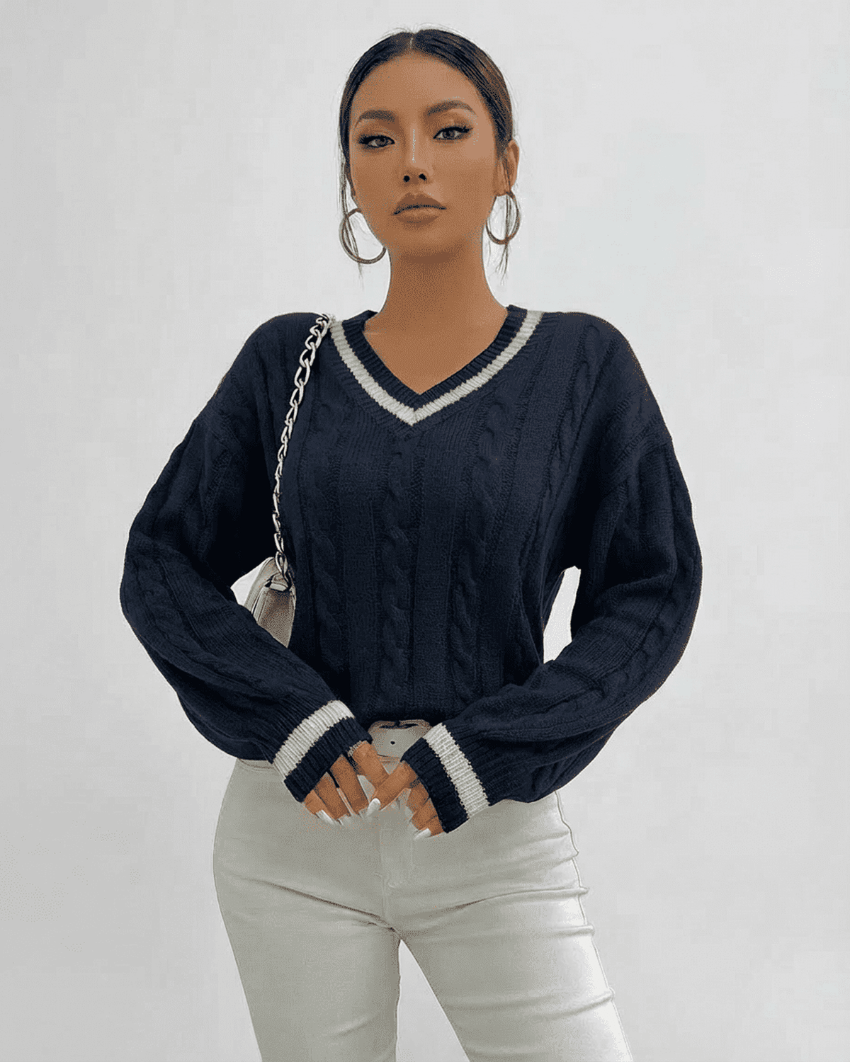 Model wearing the Marina Sweater by Lauven in navy, showcasing a cable knit design and V-neck collar.