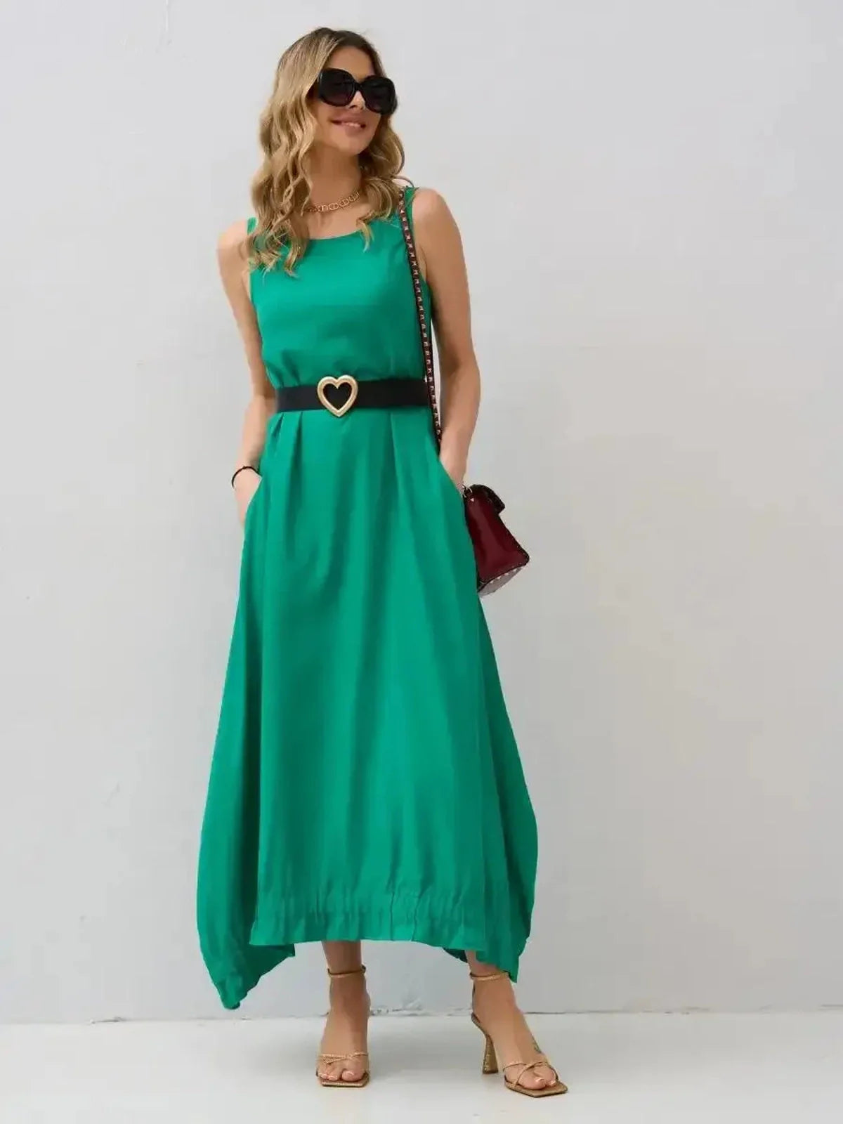 Model wearing the Maxi Dress Eden Breeze in vibrant green, featuring a flowy silhouette and chic handkerchief hem.