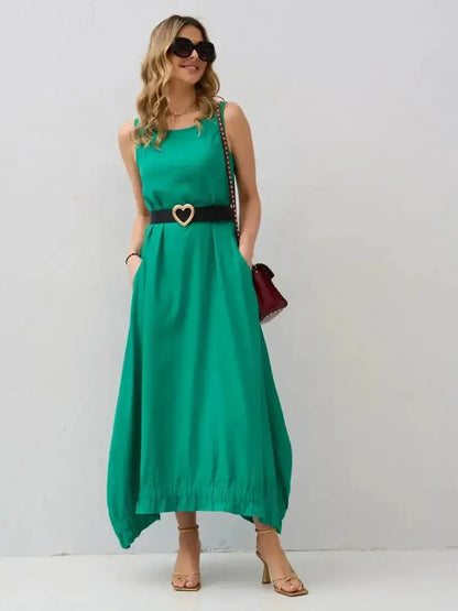 Model wearing the Maxi Dress Eden Breeze in vibrant green, featuring a flowy silhouette and chic handkerchief hem.