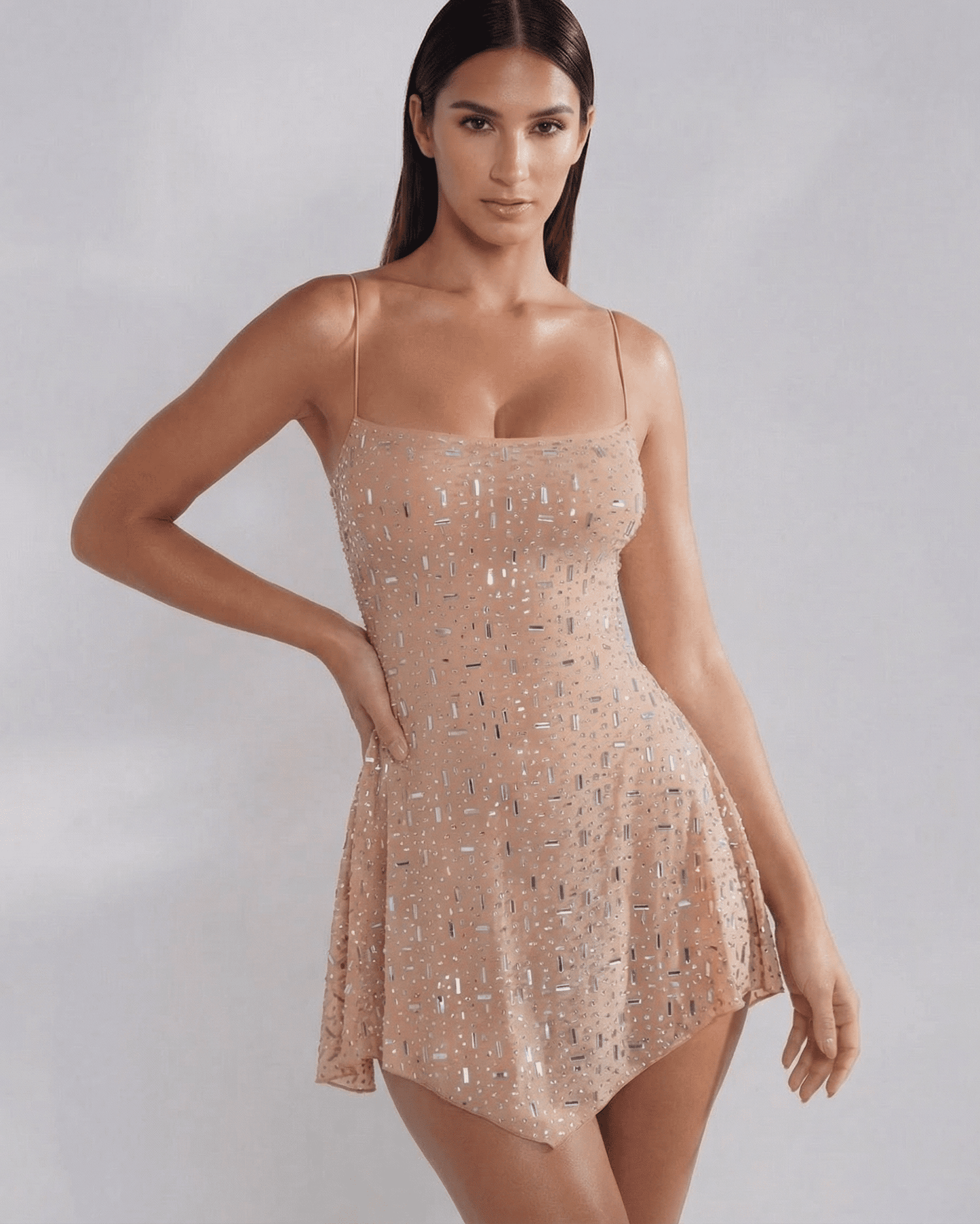 Model wearing the Monaco Mini Dress by Lauven, an embellished mermaid-style mini dress in soft nude.