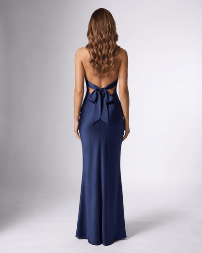 Back view of Lauven's Navelle navy blue satin maxi dress featuring a halter neck and bow detail.