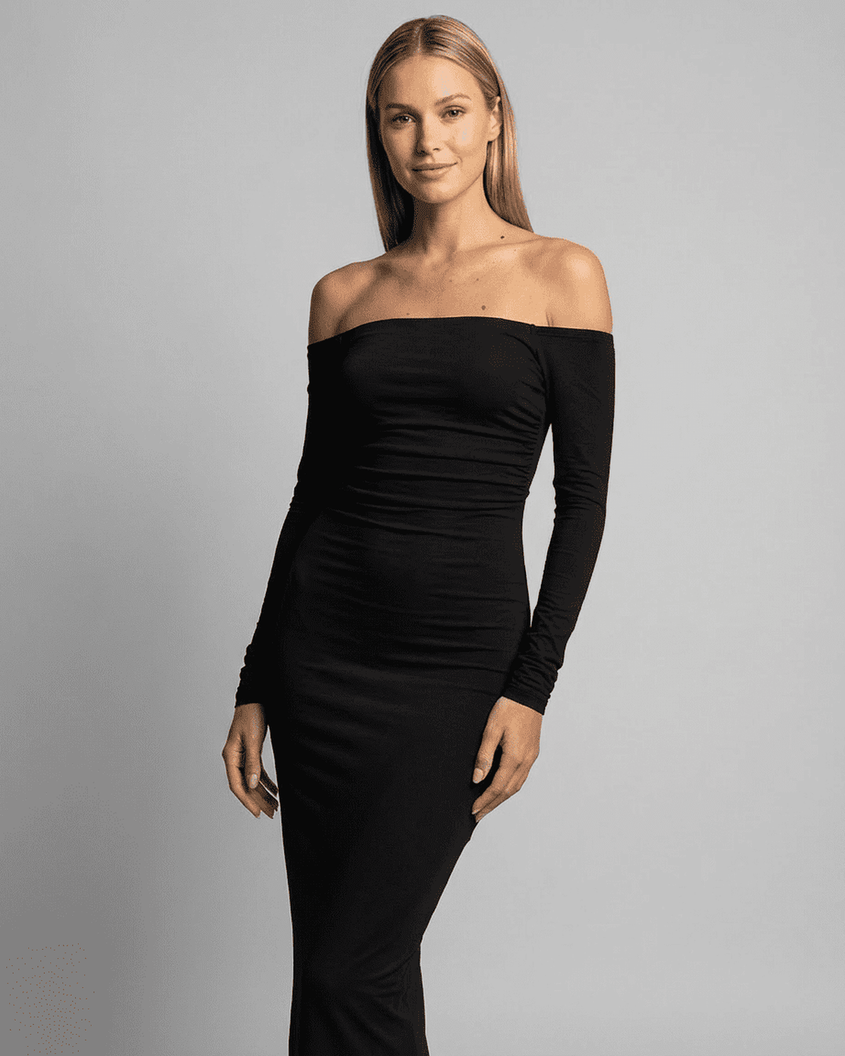 Elegant woman modeling the Lauven Nocturne Maxi Dress with off-shoulder slash neck and long sleeves.