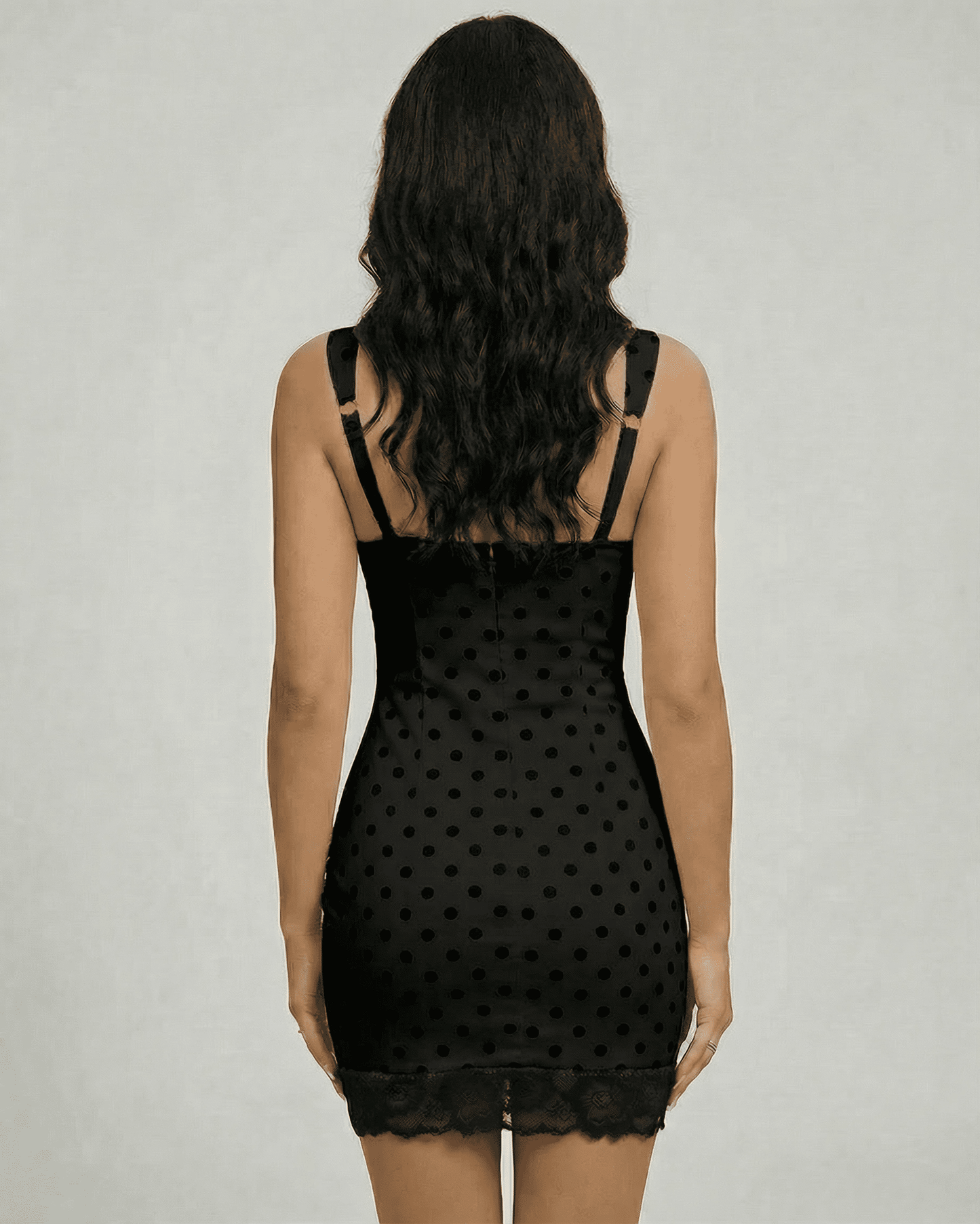 Nocturne Mini Dress by Lauven, showcasing a sleek black polka dot design with lace trim from the back view.