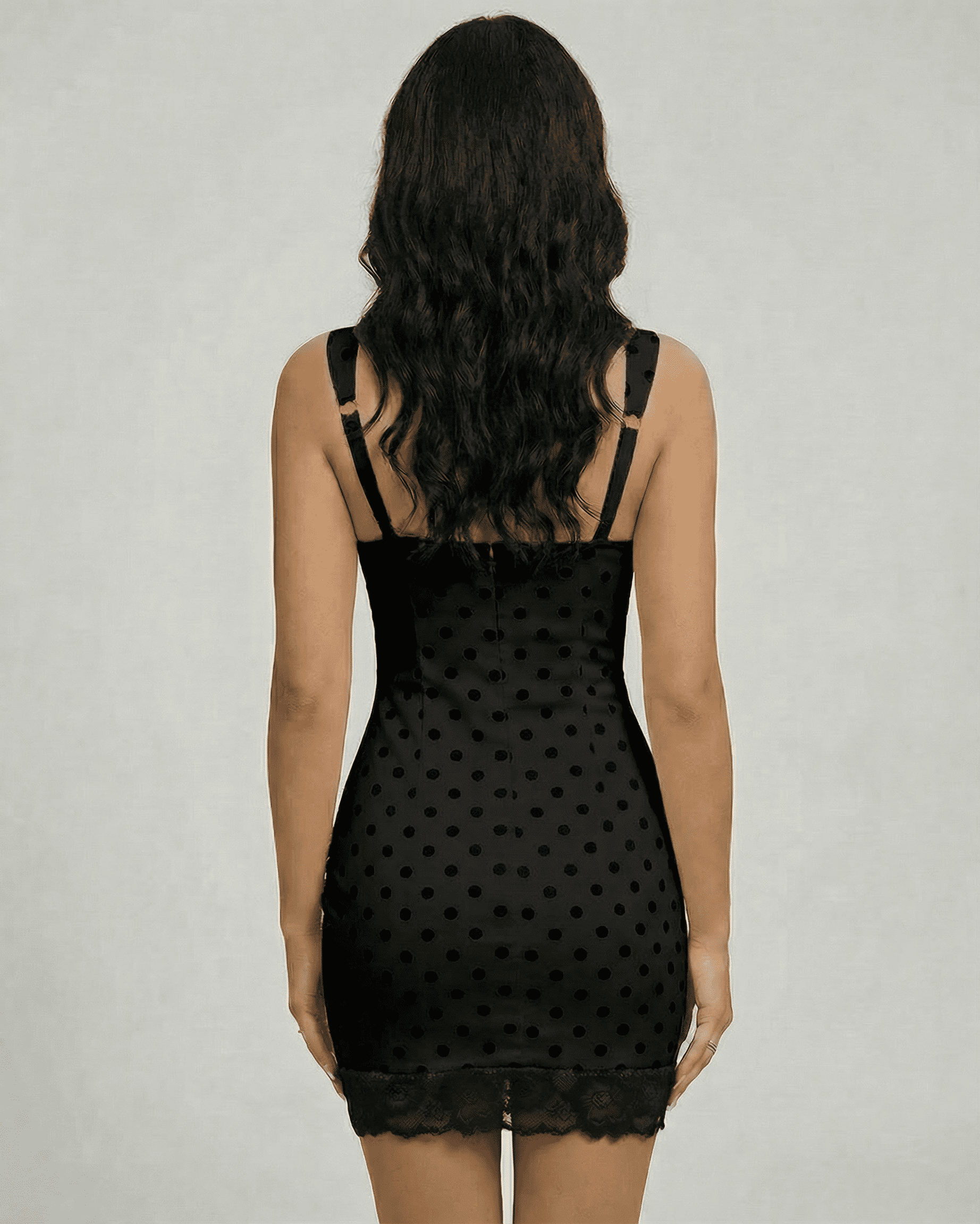 Nocturne Mini Dress by Lauven, showcasing a sleek black polka dot design with lace trim from the back view.