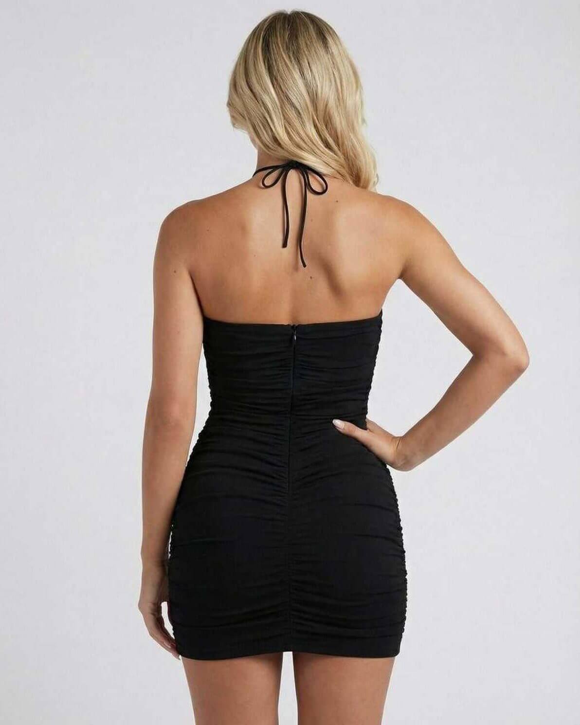 Back view of a model wearing the Lauven Noir Mini Dress with halter neck and ruched detailing in black.