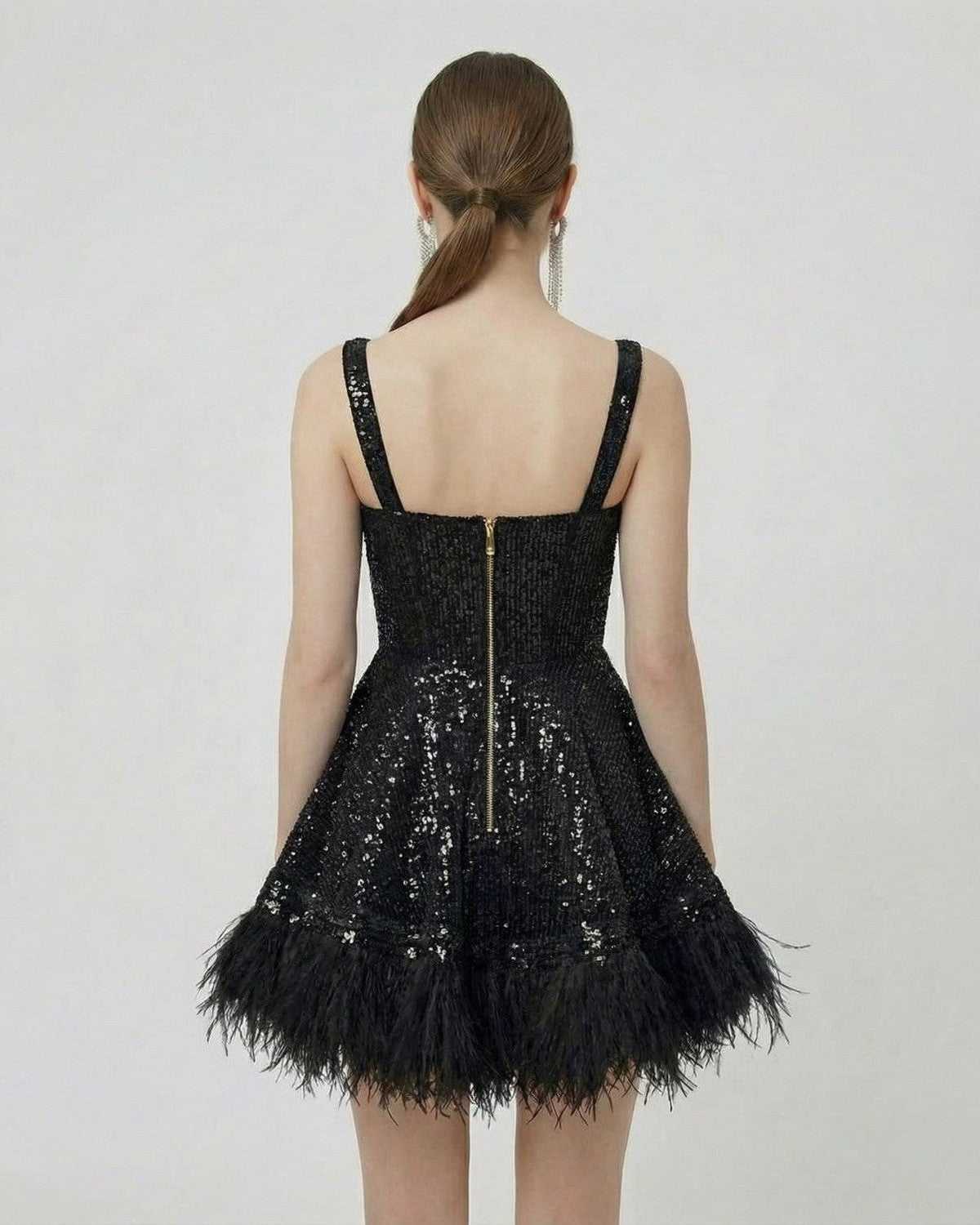 Back view of the Noir Mini Dress by Lauven, featuring black sequins and a faux fur hem, highlighting a structured A-line silhouette.