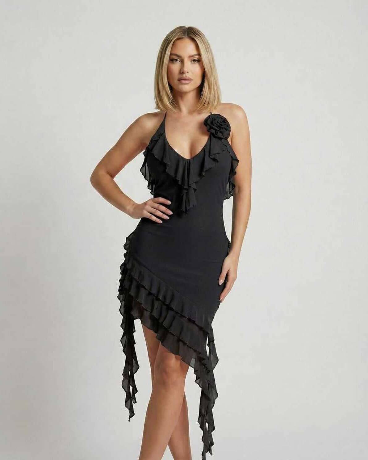 Model showcasing the Noir Mini Dress by Lauven, featuring ruffle details and an asymmetrical hemline in classic black.