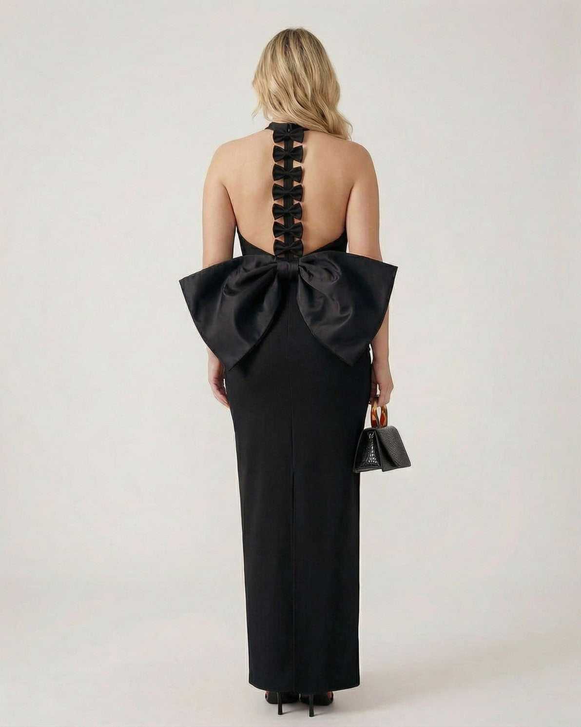 Noiré Maxi Dress by Lauven, featuring a black halter neck sheath with sculptural bow back design.