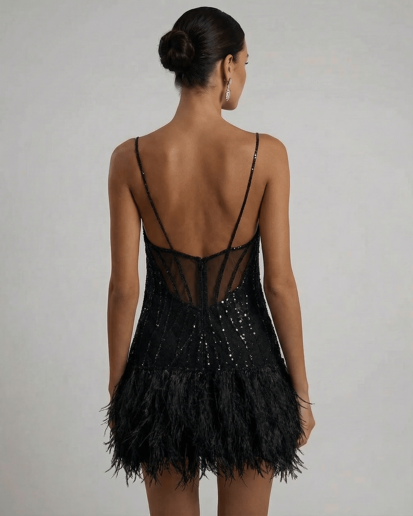 Elegant back view of the Noire Mini Dress by Lauven, showcasing the sequin tulle design and feather tassel hem.