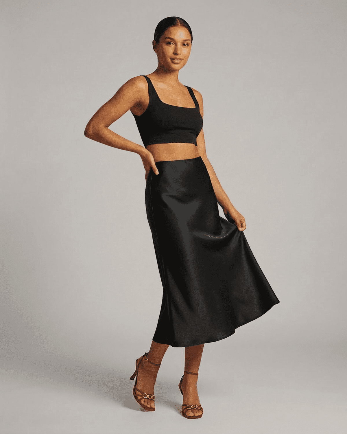 Noirelle Midi Skirt from Lauven displayed on a model, showcasing the sleek satin mermaid design in classic black.