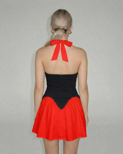 Back view of the Lauven Nova Mini Dress showcasing the vibrant red skirt and black corset panel with halter tie.