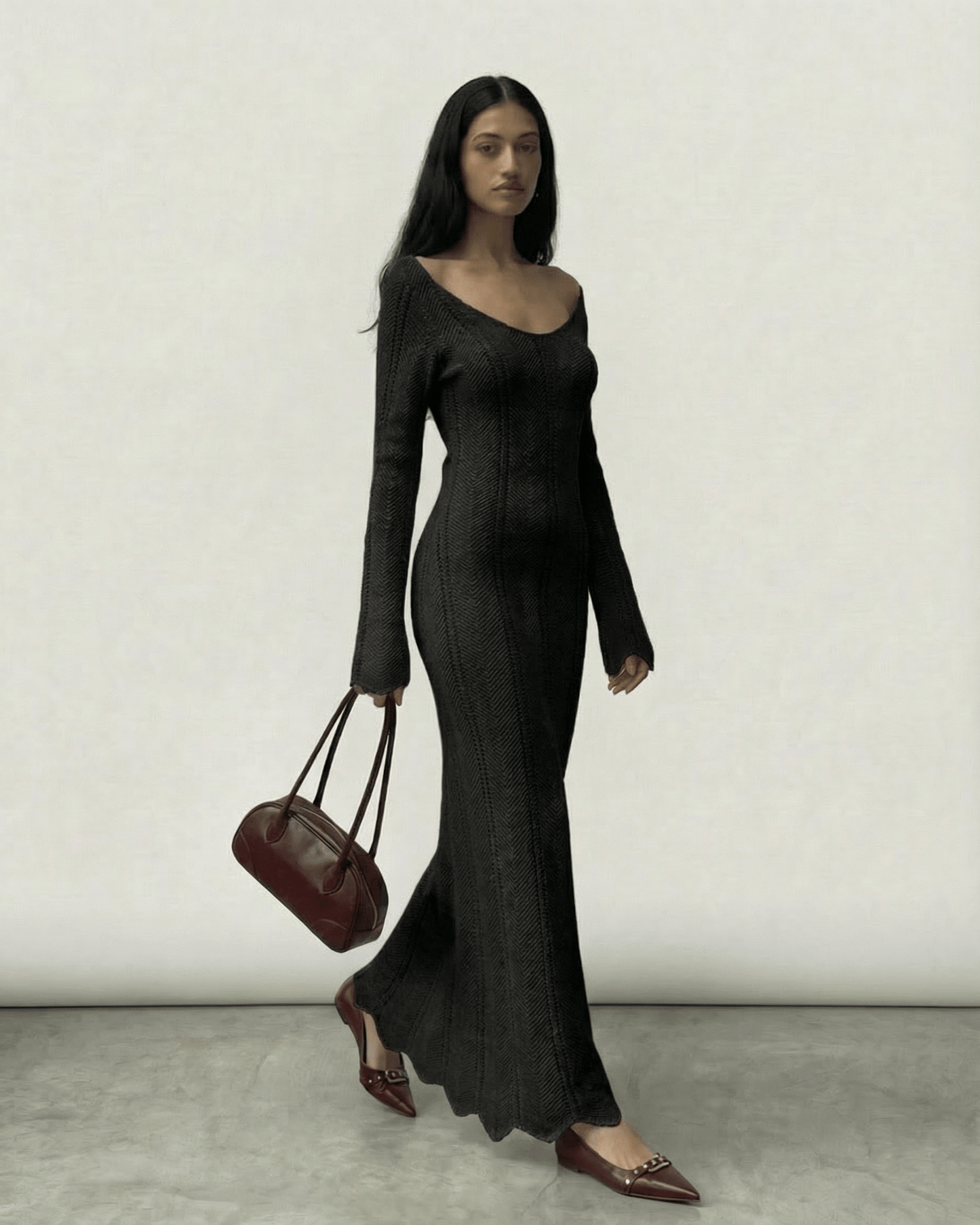 Elegant model wearing the Nyra Maxi Dress by Lauven, featuring ribbed texture and a V-neck, carrying a chic bag.