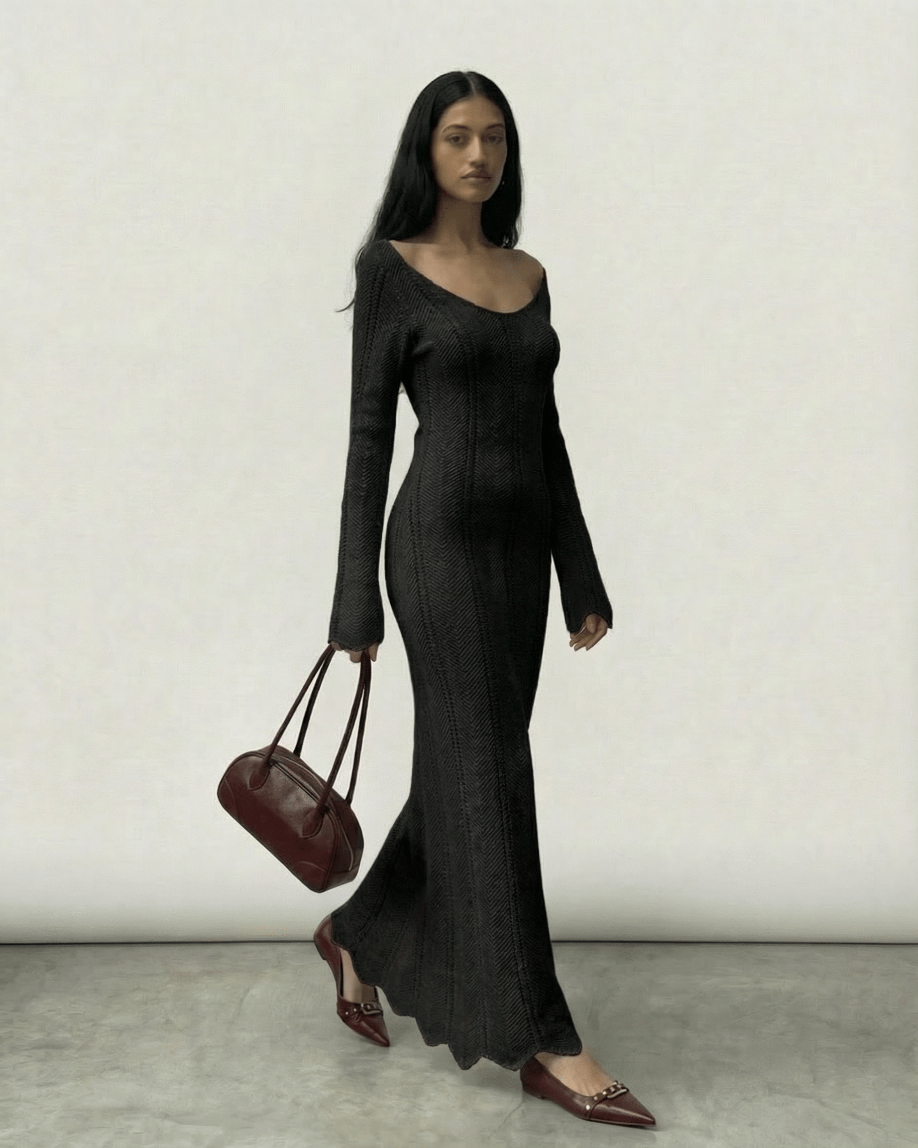 Elegant model wearing the Nyra Maxi Dress by Lauven, featuring ribbed texture and a V-neck, carrying a chic bag.