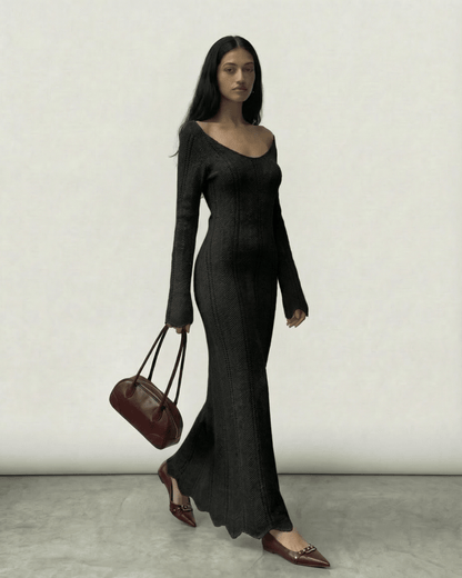 Elegant model wearing the Nyra Maxi Dress by Lauven, featuring ribbed texture and a V-neck, carrying a chic bag.