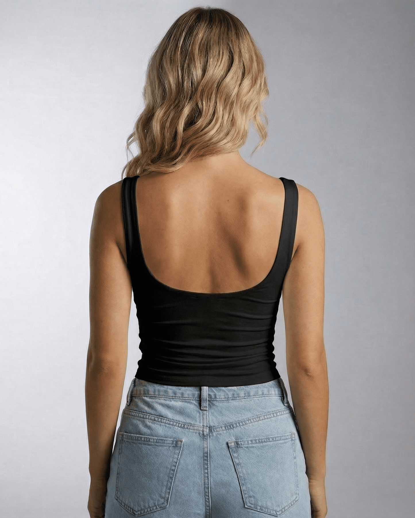 Back view of a woman wearing the Nyra Top from Lauven, featuring a sleek, sleeveless design.