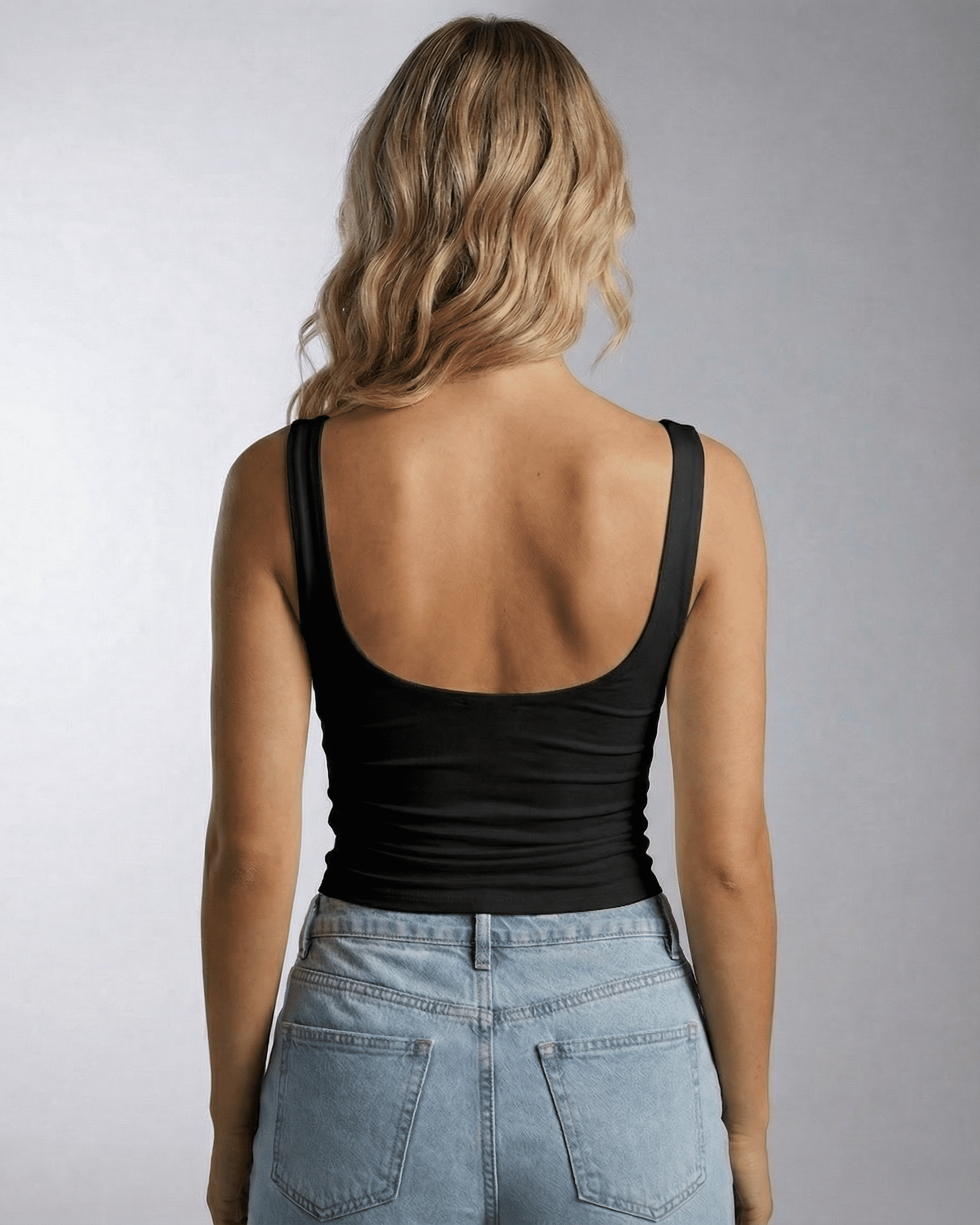 Back view of a woman wearing the Nyra Top from Lauven, featuring a sleek, sleeveless design.