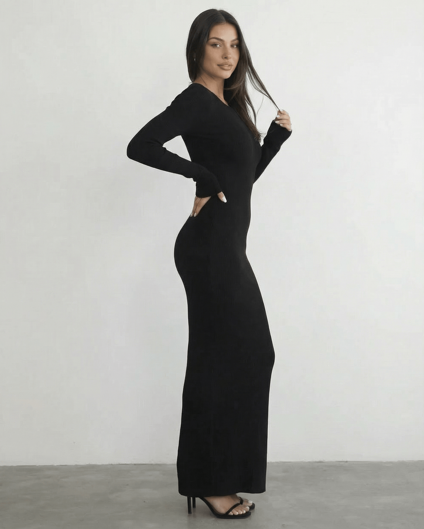 Model wearing the Nyx Maxi Dress by Lauven, a long sleeve black dress featuring an open back detail.
