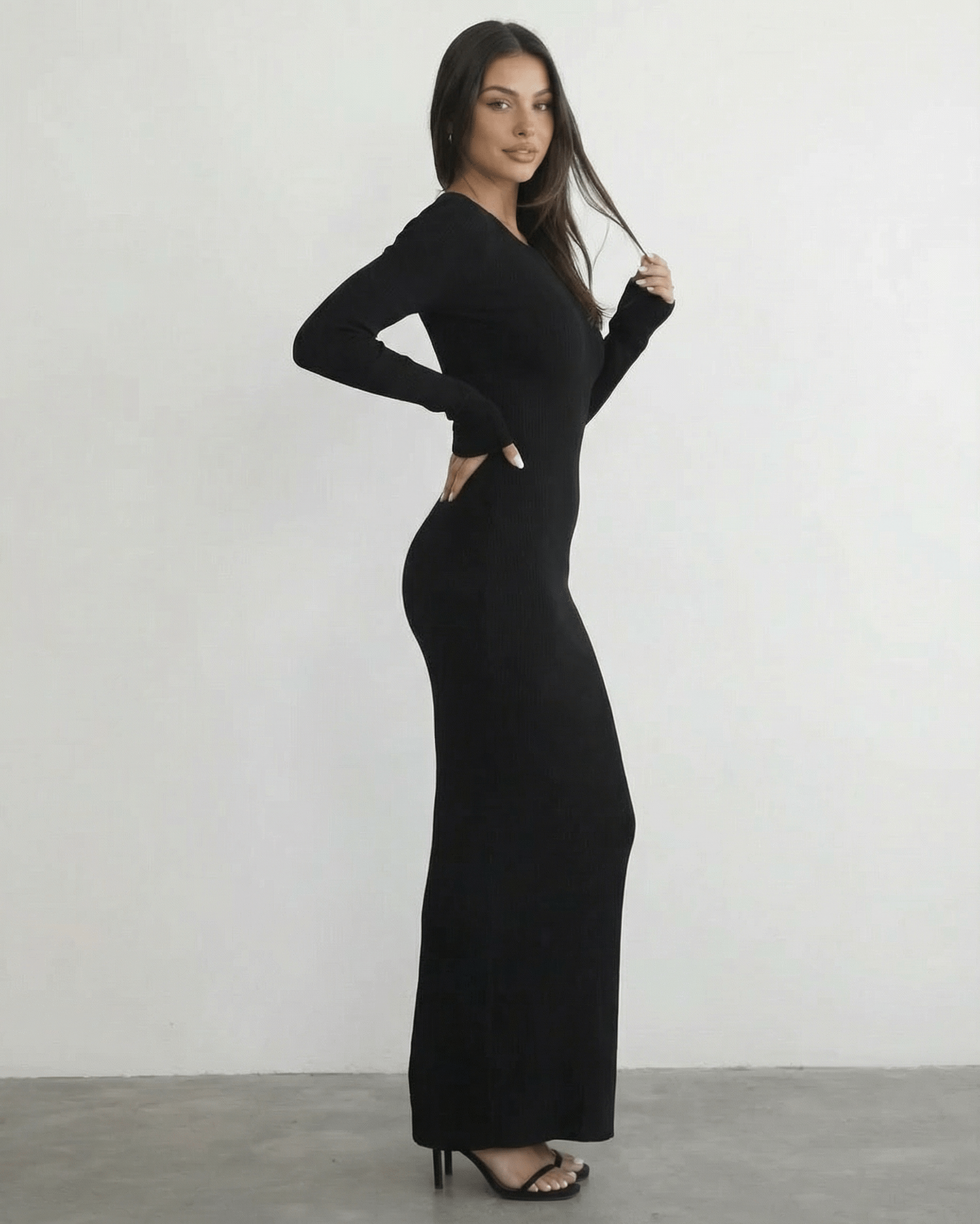 Model wearing the Nyx Maxi Dress by Lauven, a long sleeve black dress featuring an open back detail.