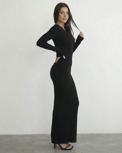 Model wearing the Nyx Maxi Dress by Lauven, a long sleeve black dress featuring an open back detail.