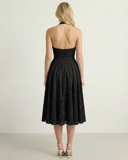 Back view of the Nyx Midi Dress by Lauven, showcasing a textured black A-line silhouette with a halter neck design.