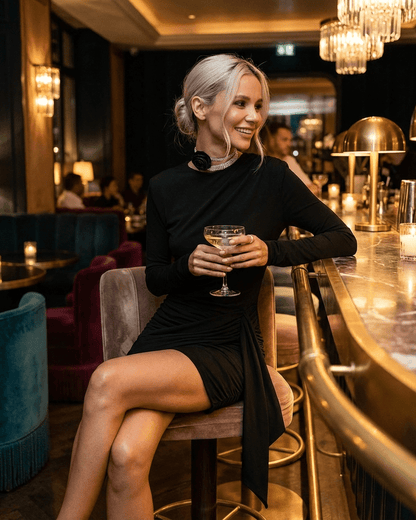Onyx Mini Dress by Lauven, showcasing a model in a bar, radiating sophistication and style with a cocktail.