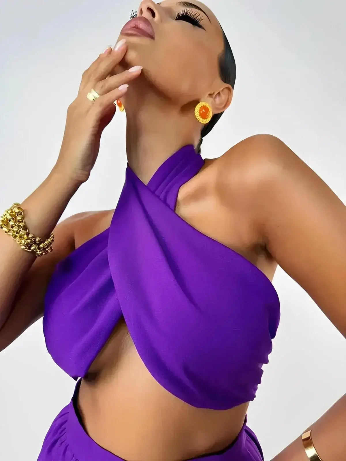 Model showcasing the Orchid Drape Set halter top by Lauven, featuring a wrapped design in vibrant purple.