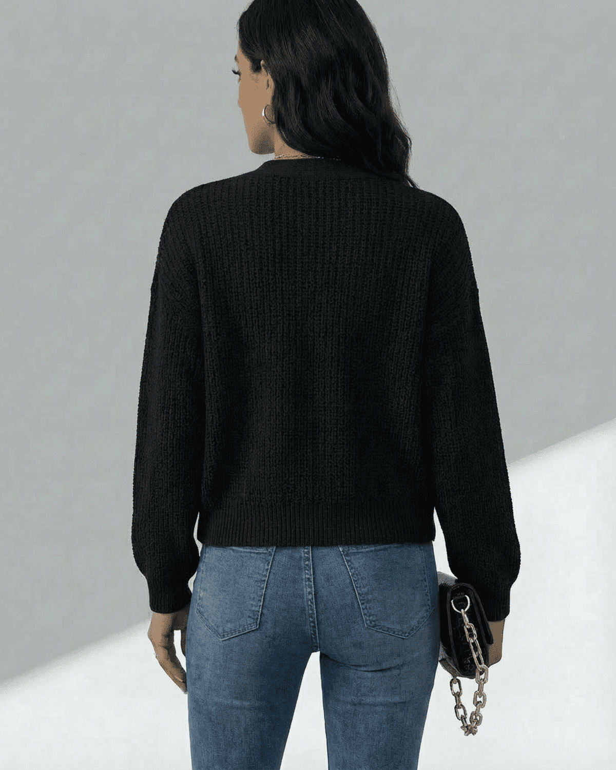 Back view of a model wearing the Lauven Orion Cardigan, showcasing its stylish and comfortable design in black.