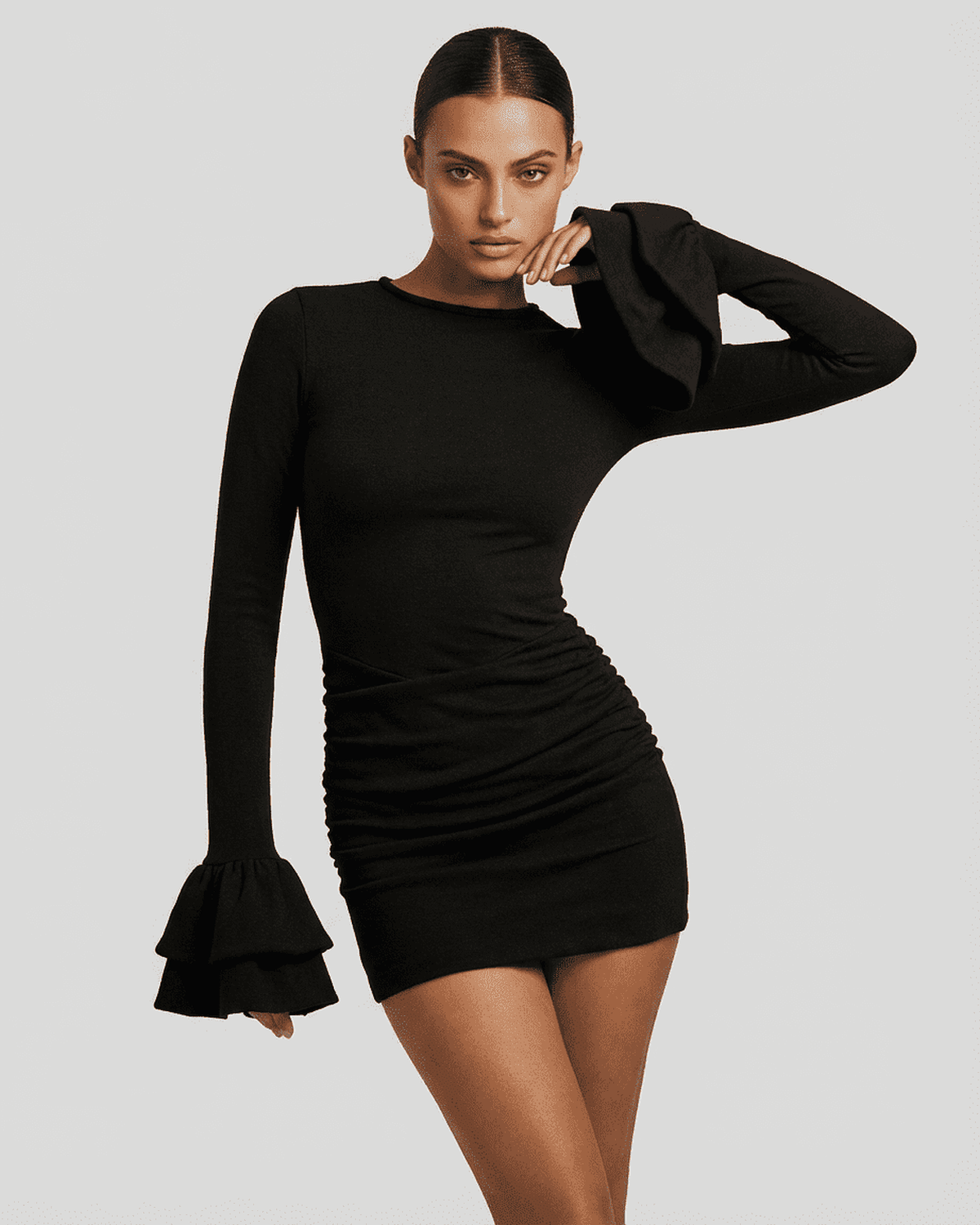 Model wearing the Orion Mini Dress by Lauven, showcasing ruffled sleeves and a flattering bodycon fit in black.