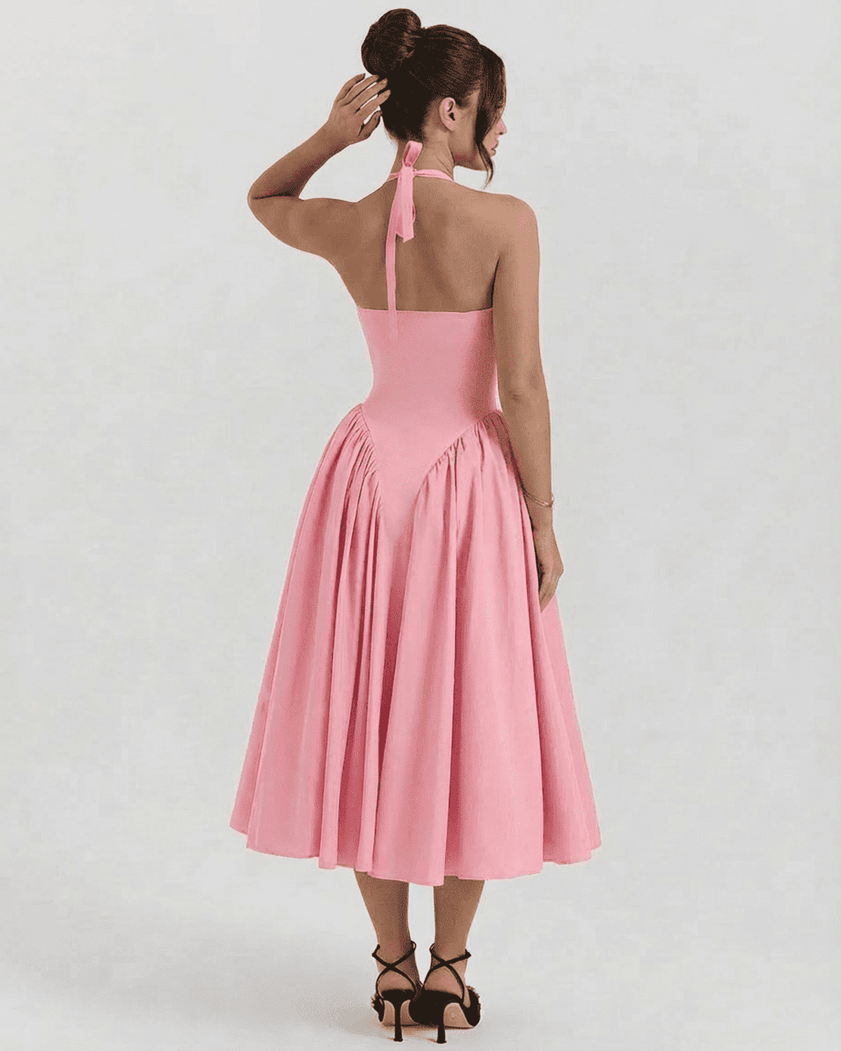 Back view of the Pink Celeste Midi by Lauven, showcasing the halter neck and backless design with a flowing skirt.