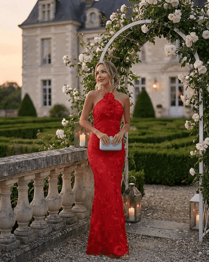 Rosalia Maxi Dress by Lauven, elegant halter neck design in bold red with 3D floral detail in a picturesque garden setting.