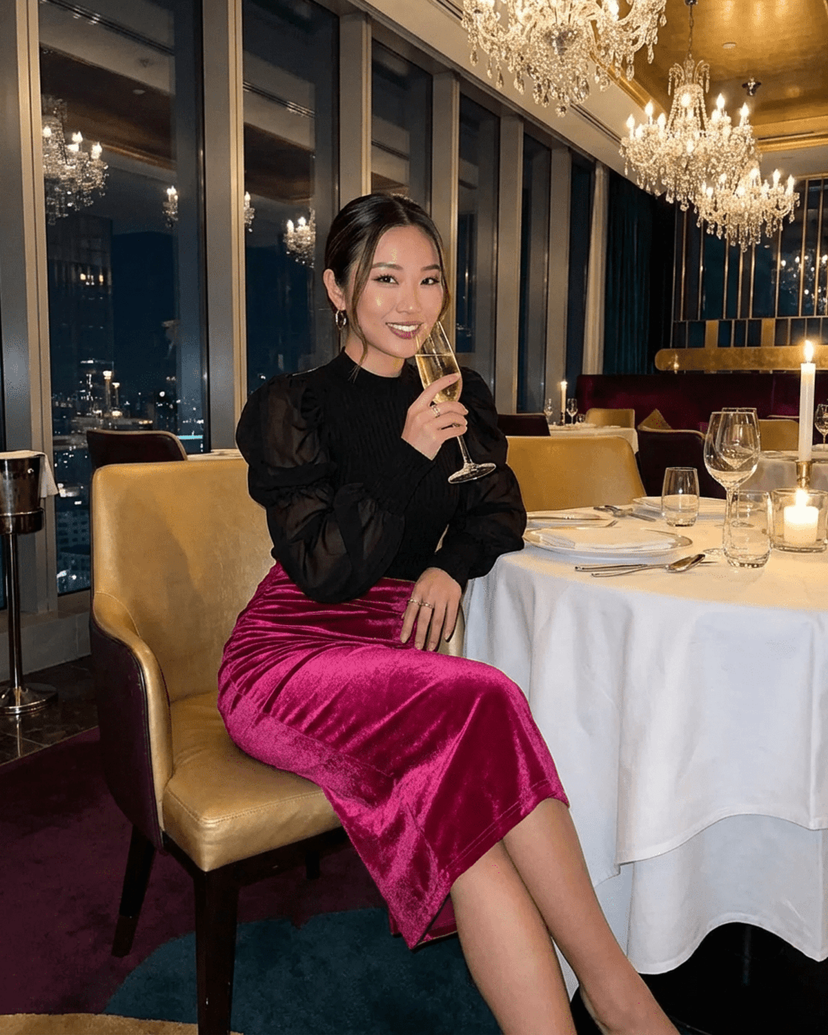 Model wearing Rosalia Midi Skirt by Lauven in a glamorous restaurant setting, highlighting its velvet texture and elegant style.