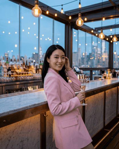 Rosalie Blazer worn by a woman holding a champagne glass in a chic bar setting, showcasing the Lauven brand.