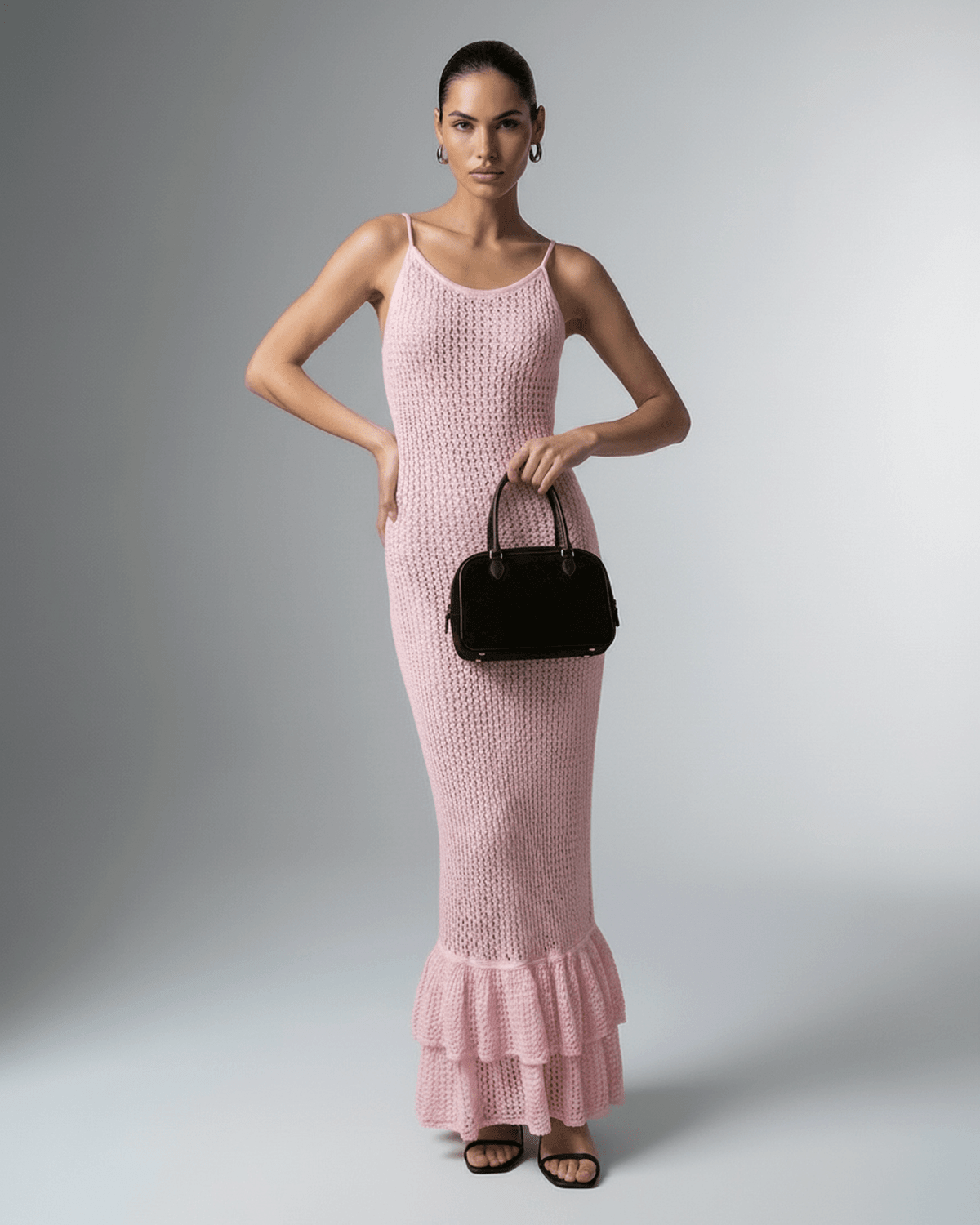 Model wearing Rosaline Maxi Dress by Lauven, a pink bodycon maxi with hollow out knit and ruffle hem detail.