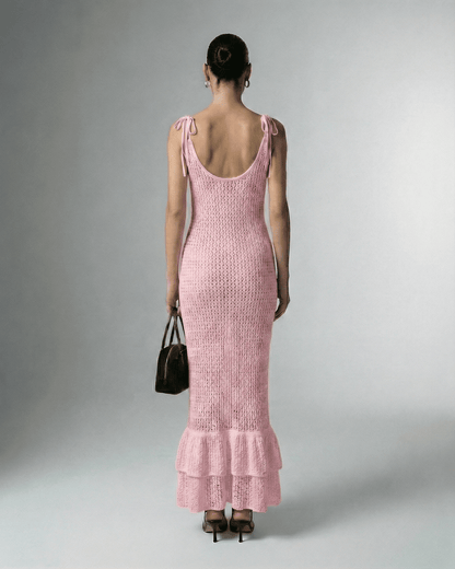 Back view of a model wearing Rosaline Maxi Dress by Lauven, showcasing its stylish pink hollow out knit design.