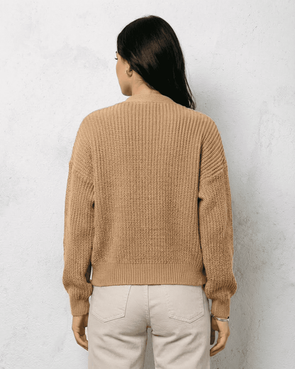 Back view of a woman wearing the Saffron Cardigan by Lauven, showcasing its elegant beige knit design.