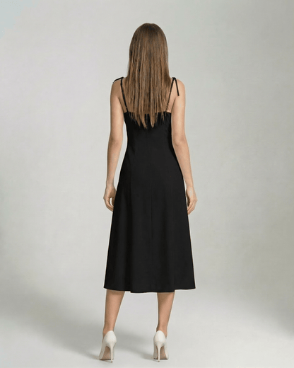 Back view of a woman wearing the Selene Midi Dress by Lauven, an elegant black midi dress with tie straps.