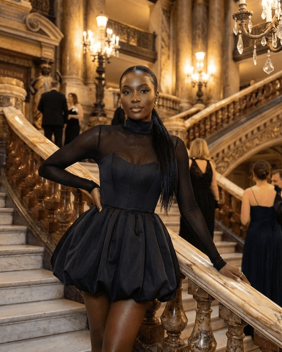 Elegant model wearing Selene Mini Dress by Lauven with a bubble hem, posing on grand stairs in an upscale venue.