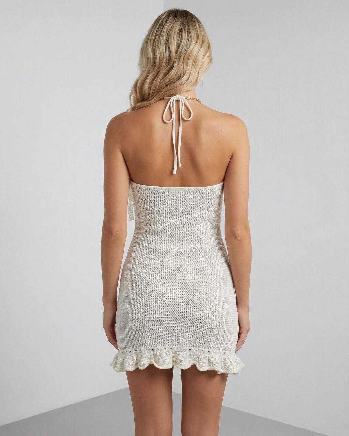 Lauven Serena Mini Dress back view showcasing halter neck, pleated design, and ruffle hem in soft cream color.