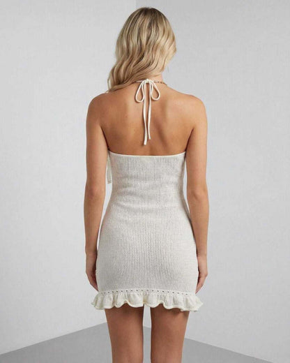 Lauven Serena Mini Dress back view showcasing halter neck, pleated design, and ruffle hem in soft cream color.