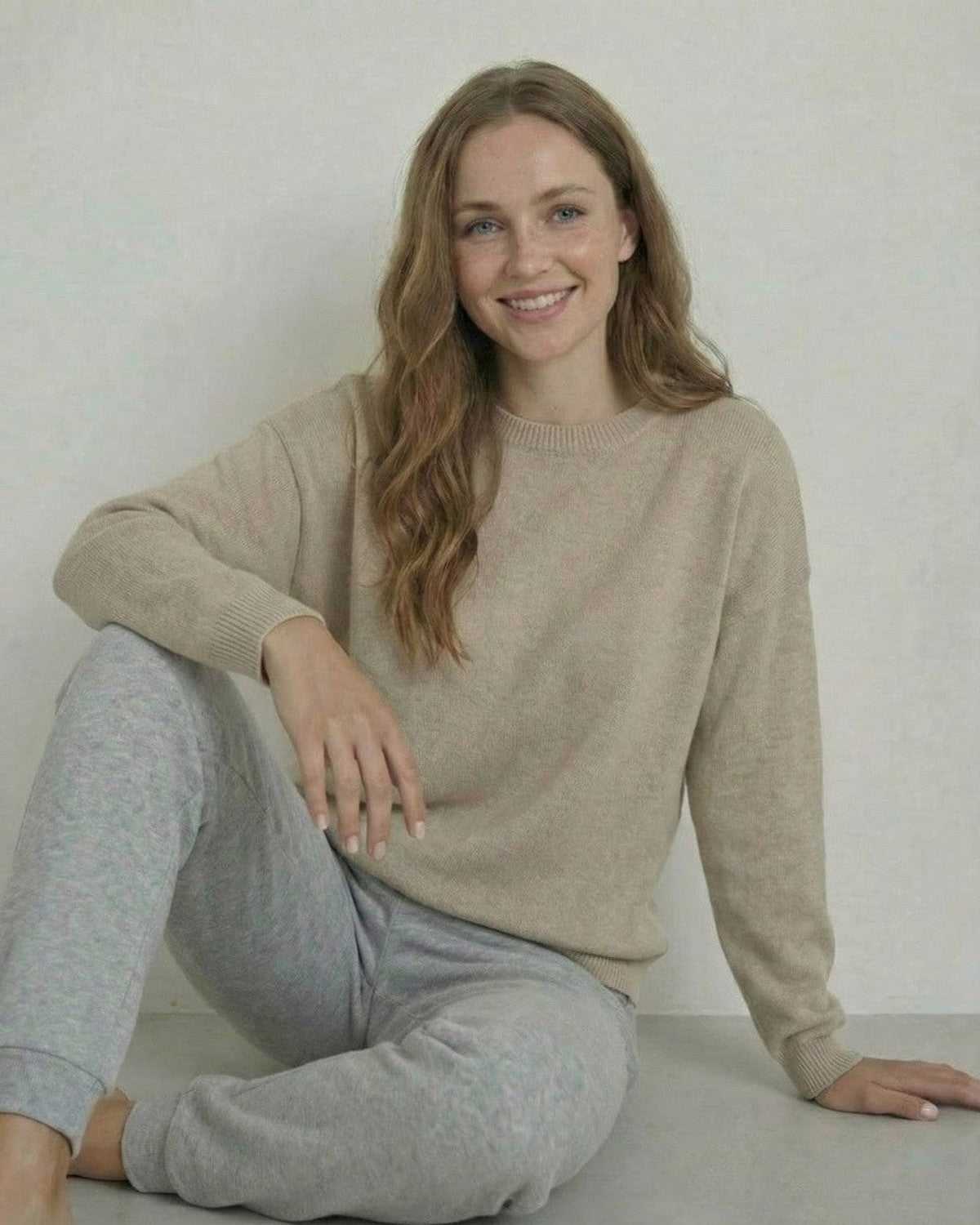 Woman wearing Siena Pullover by Lauven, a soft wool knit sweater, paired with gray sweatpants.