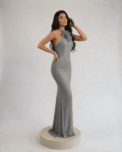 Lauven Silver Maxi Dress with halter neck and floral accent, showcasing elegance in silver-gray shimmer.