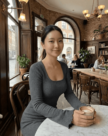 Woman in a Slate Maxi Dress by Lauven, seated at a café table holding a cup.