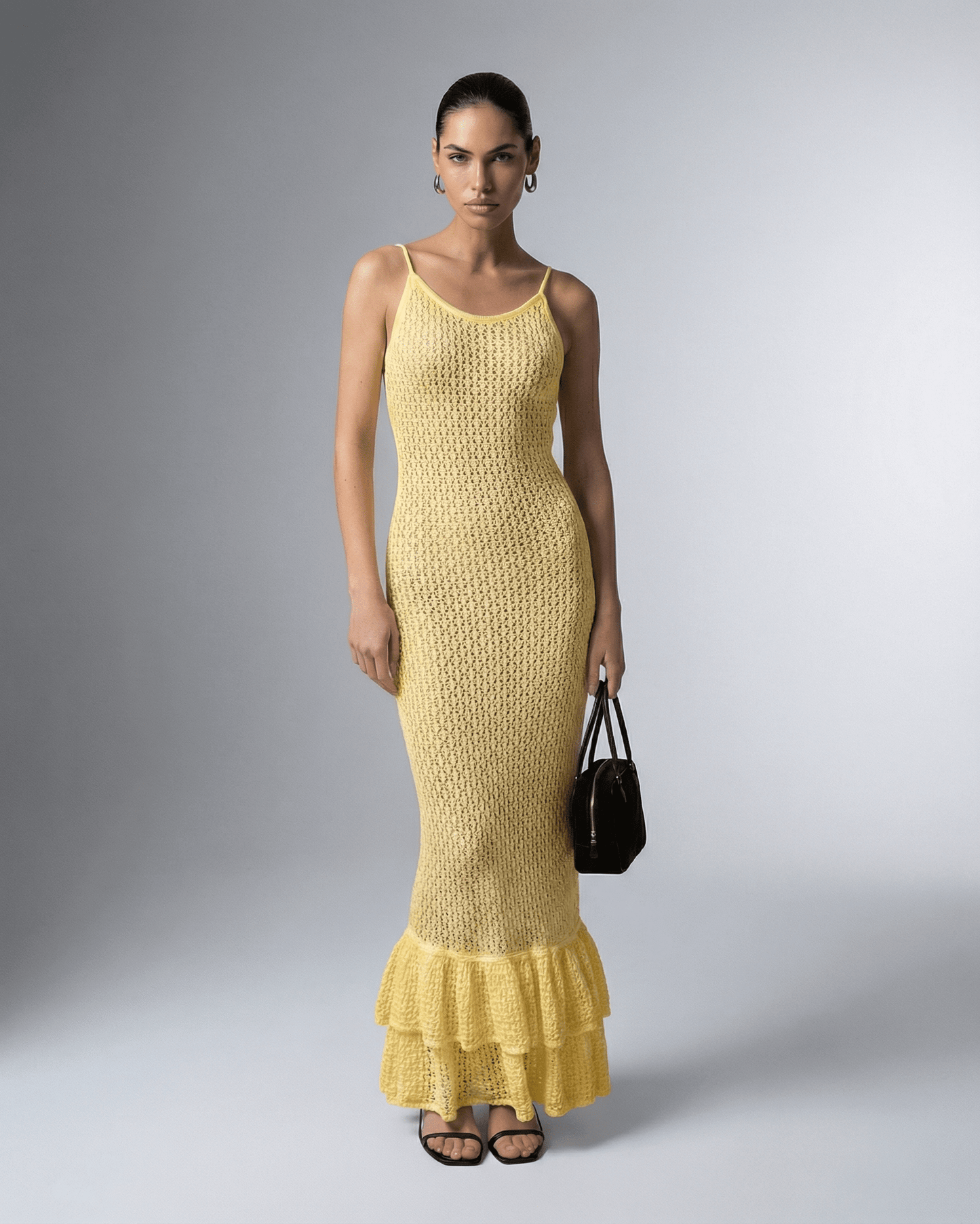 Model wearing the Solara Maxi Dress by Lauven, a yellow bodycon maxi dress with hollow out detail.