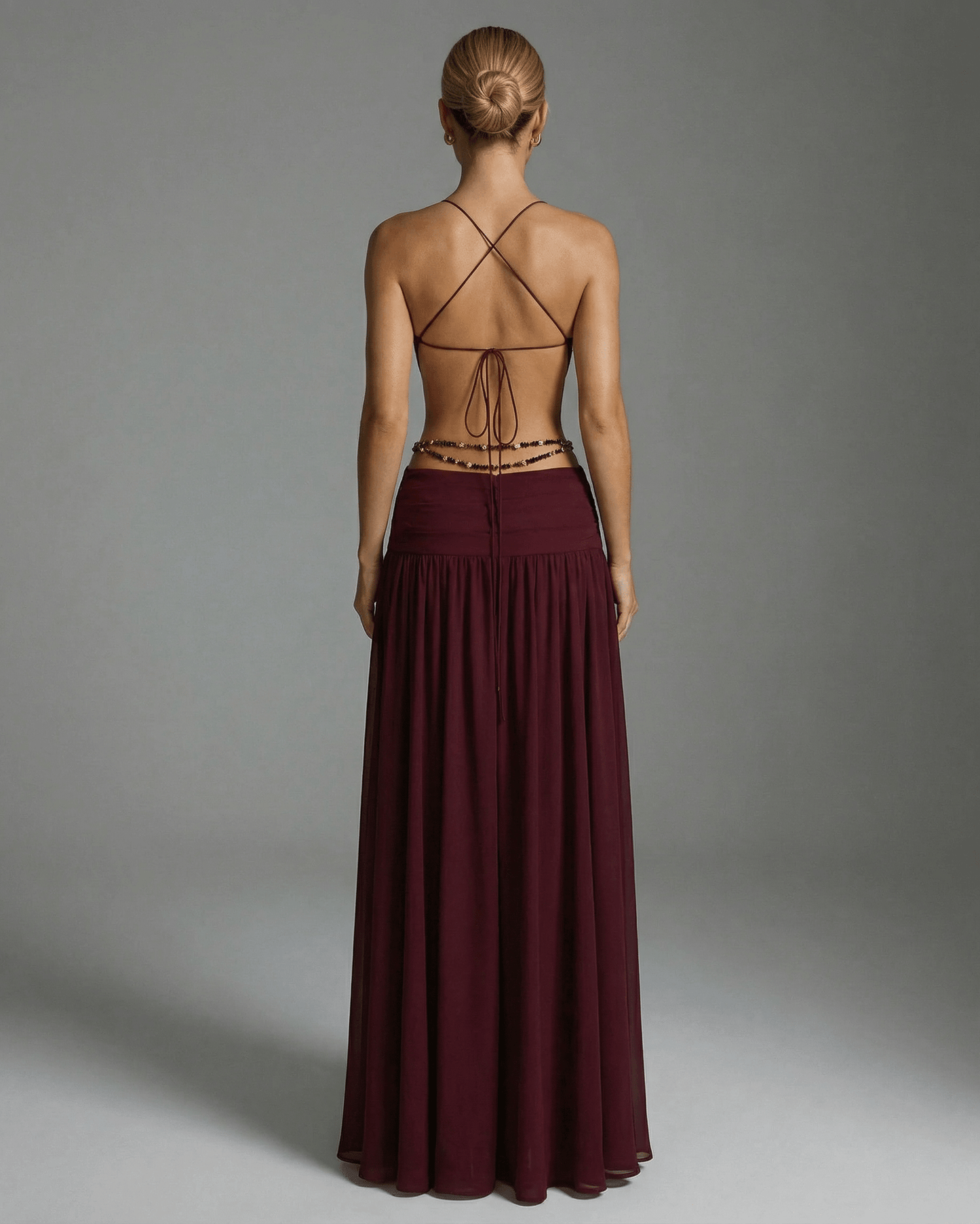 Back view of the Valencia Maxi Dress by Lauven, featuring a burgundy color and an elegant open back design.