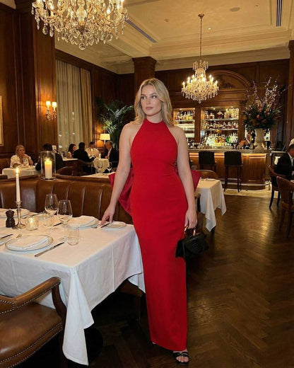 Valencia Maxi Dress by Lauven worn by a woman in a red halter neck sheath dress at a stylish restaurant.