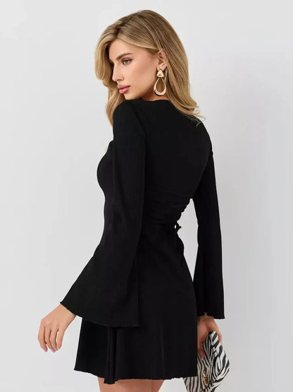 Model showcasing the Velvet Hour mini dress by Lauven, featuring flared cuffs and a structured U-neckline.